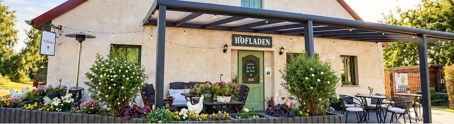 Der Hofladen der Weidelandfarm mit bepflanzter Terrasse und Sitzplätzen